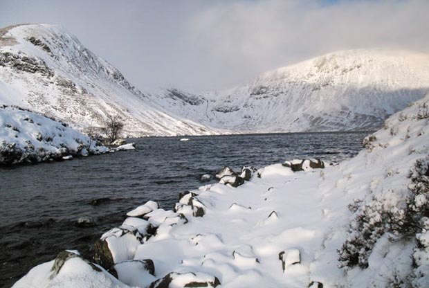 Snow covered Mid Craig and Lochcraig Head with Loch Skene in the foreground.