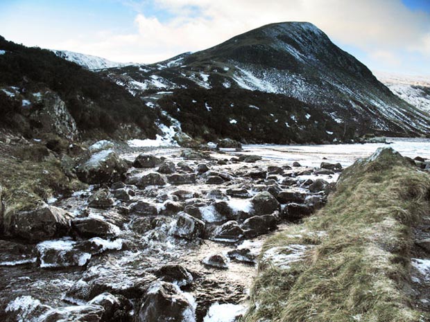 View of ice on the Tail Burn as it runs out of Loch Skene with Mid Craig behind.