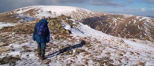 Approaching the cairn on the top of Millfire with the flat top of Corserine beyond