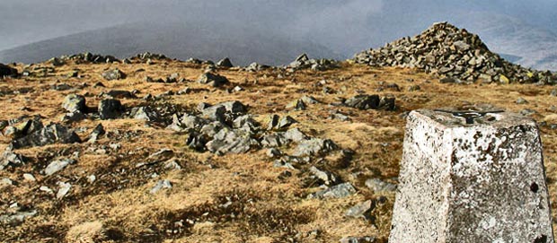 Trig point and cairn on the top of Meikle Millyea in mist