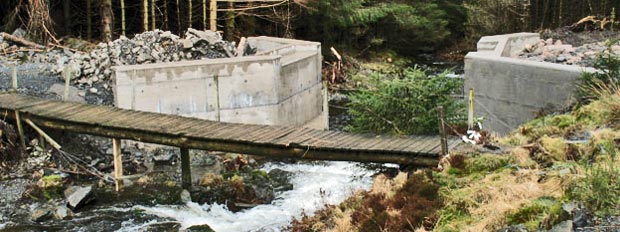 View of old wooden bridge and new concrete one being built