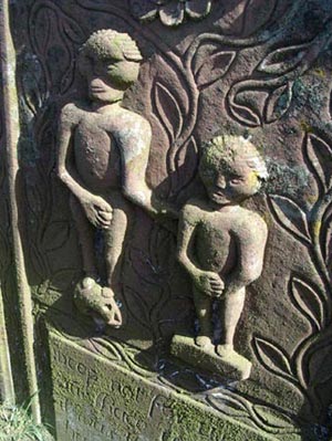 Old gravestone with high relief image of Adam and Eve