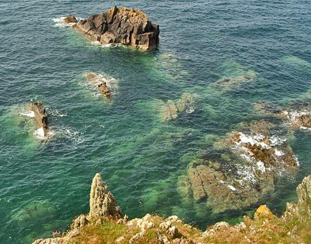 Restless sea playing over submerged rocks