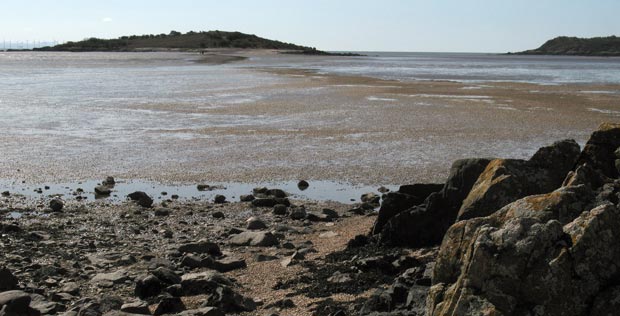 View of the causeway to Rough Island from the shingle beach at the end of the shore road Kippford.