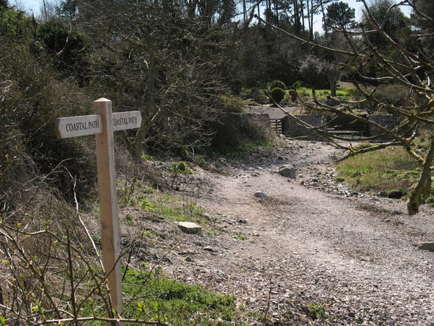 Coastal path waymarker on the shore - heading for Castle Point.